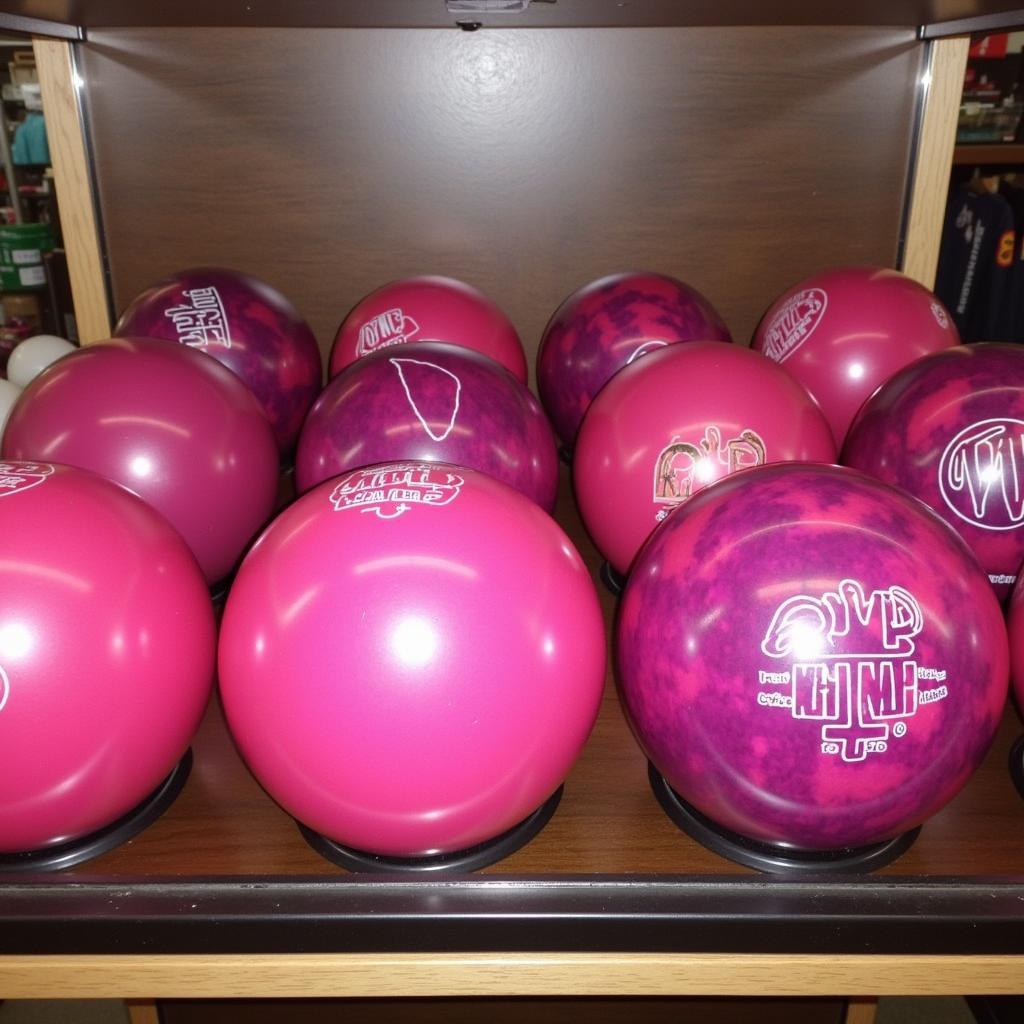 A selection of pink bowling balls showcasing different designs and finishes