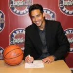 Anthony Edwards signing a basketball for a fan