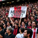 Beşiktaş fans holding a banner displaying "54 Meadow Street" during a match.