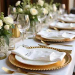 Gold disposable chargers adorn a wedding reception table setting