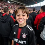 Young Beşiktaş fan proudly sporting Ketel Marte youth jersey during a match.