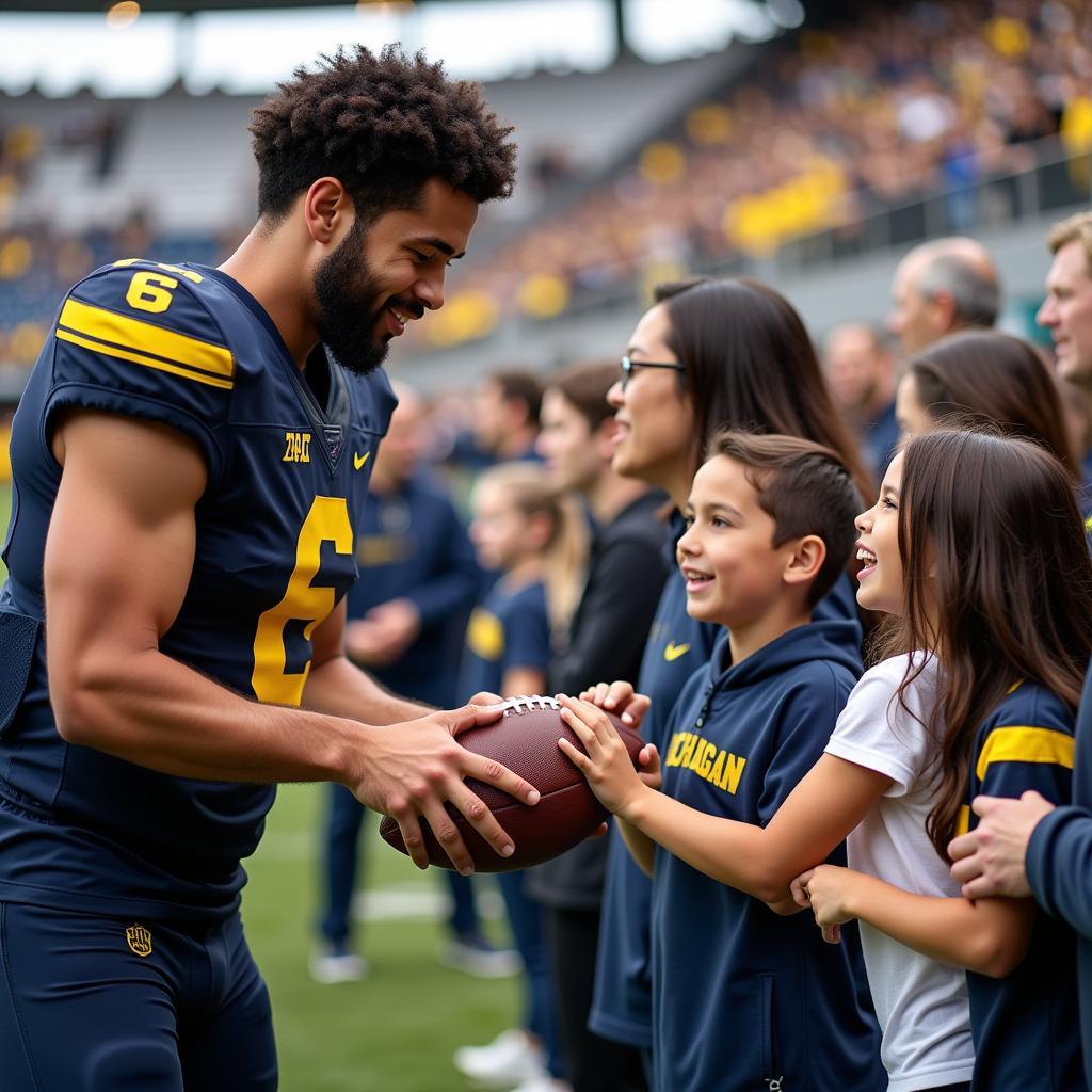 A Michigan football player signing a football for a fan at a meet-and-greet event.