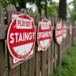 Small no trespassing signs attached to a wooden fence