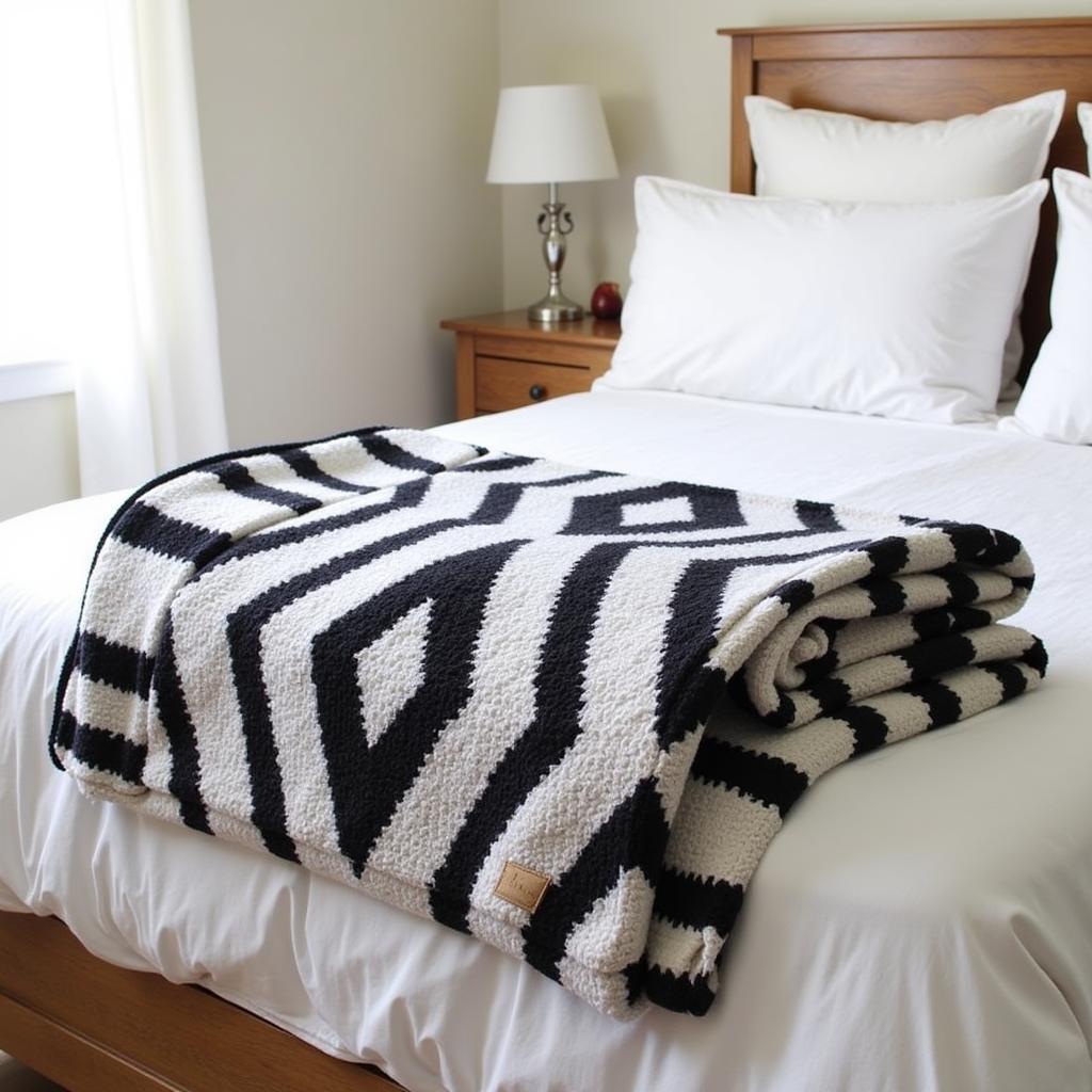  Throw blanket with a bold geometric pattern neatly arranged at the foot of a bed