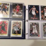 A collection of Donovan Mitchell rookie cards in protective cases.