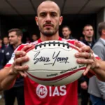 Steve Young Autographed Football Held by a Besiktas Fan